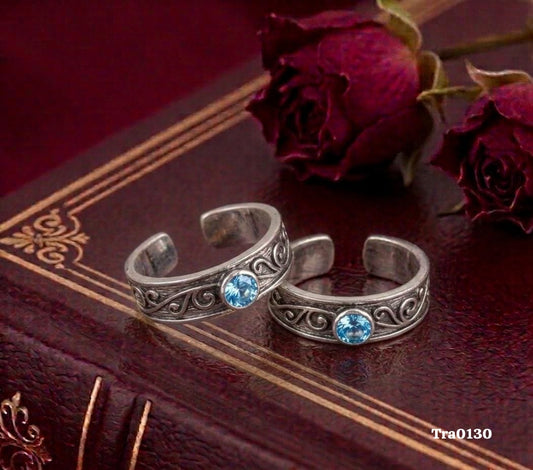 Oxidized band Silver Toe Rings with an intricate swirling pattern and a central light blue stone